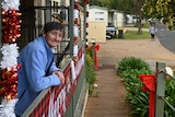 A woman in front of cabins at a caravan park