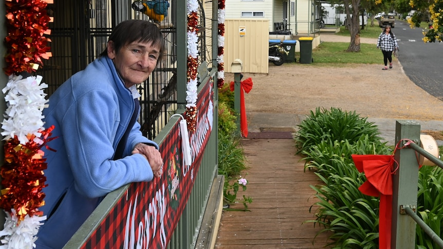 A woman in front of cabins at a caravan park