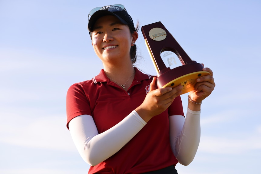 Rose Zhang smiles while holding a trophy up