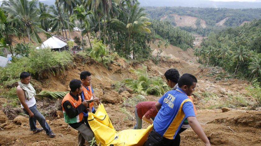 Workers carry quake victim in West Sumatra