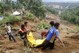 Workers carry quake victim in West Sumatra