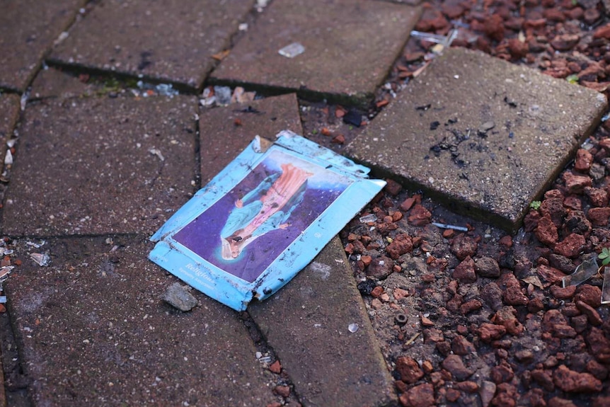 A card with a religious icon in seen on the ground at the scene of a fire at a home in West Footscray.