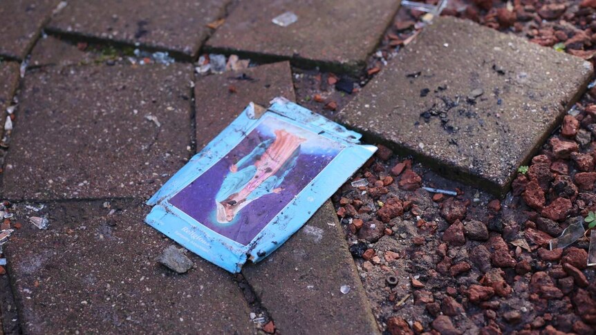 A card with a religious icon in seen on the ground at the scene of a fire at a home in West Footscray.