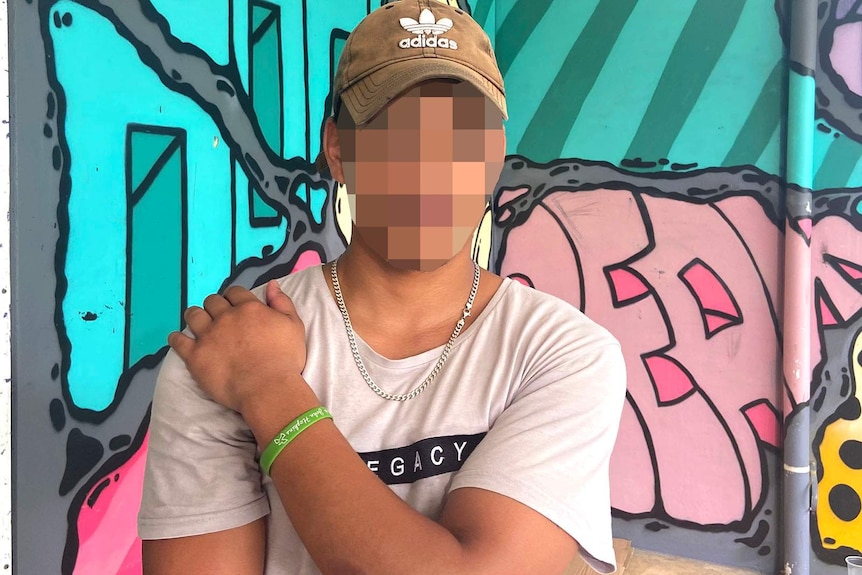 A young man whose face has been blurred to protect his identity
