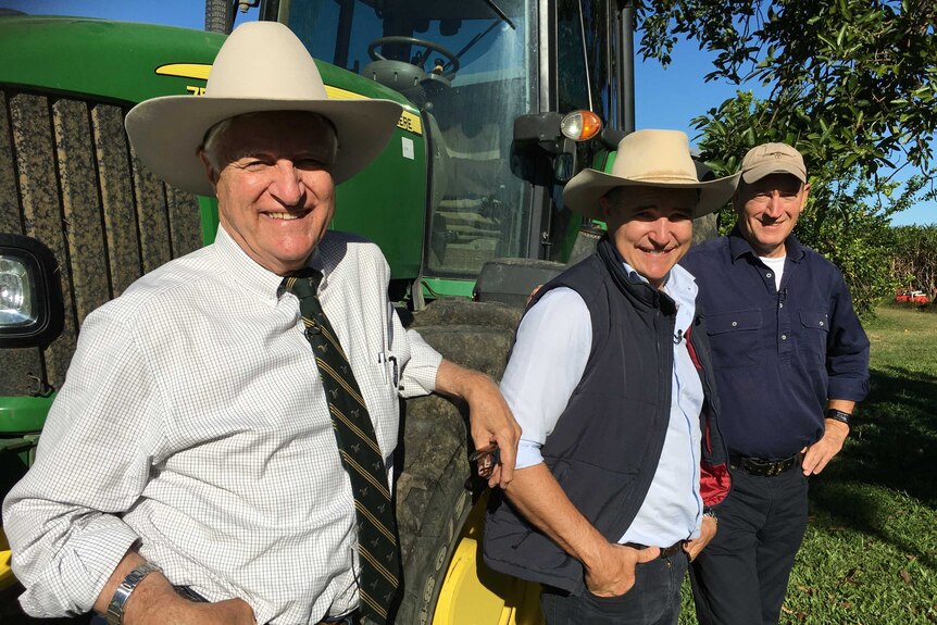 Bob Katter (l), Robbie Katter (c) and Fraser Anning (r) pose in front of a tractor