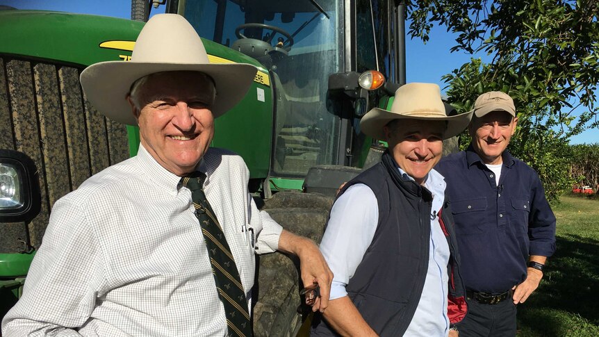 Bob Katter (l), Robbie Katter (c) and Fraser Anning (r) pose in front of a tractor