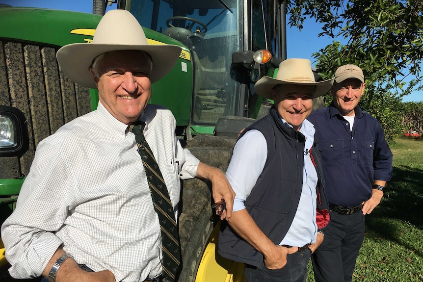 Bob Katter (l), Robbie Katter (c) and Fraser Anning (r) pose in front of a tractor