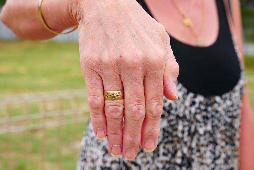 Woman's hand showing a gold ring with star details.