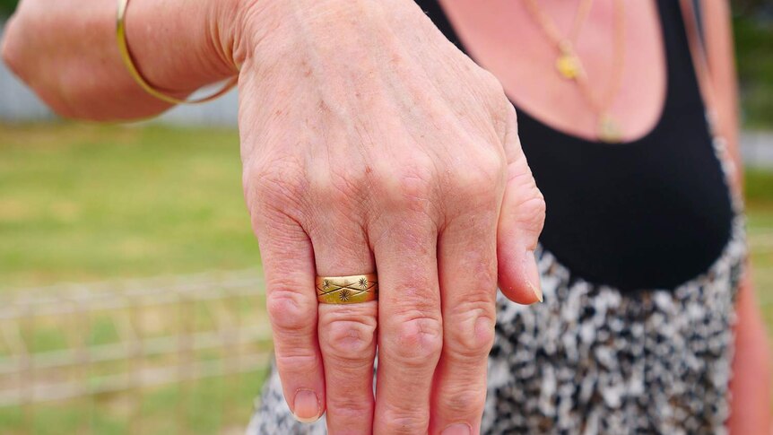 Woman's hand showing a gold ring with star details.