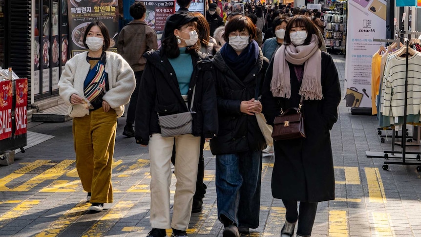 A group of young Korean women walking through a market in Seoul