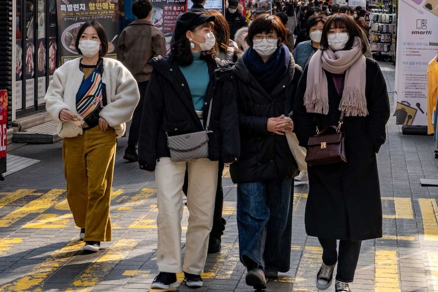 A group of young Korean women walking through a market in Seoul