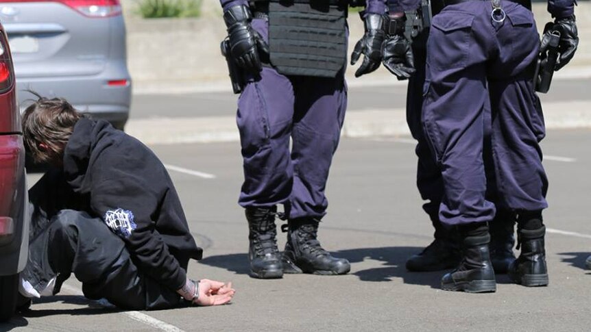 Heavily armed police arrest a man