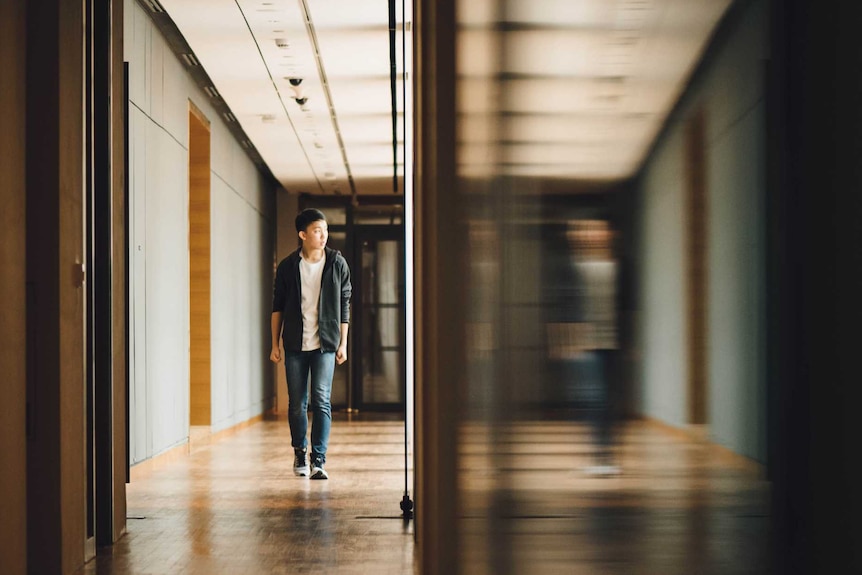 Young boy walks down hallway at school.