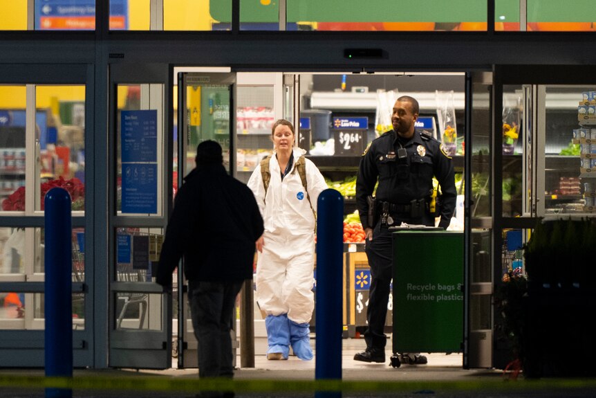 A woman in proetctive covering walks trhugh the doors of a Walmart supermarket. 