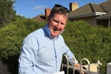 South Australian Liberal MP Terry Stephens drops off election material in a letterbox.