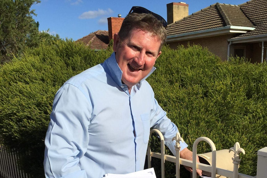 South Australian Liberal MP Terry Stephens drops off election material in a letterbox.