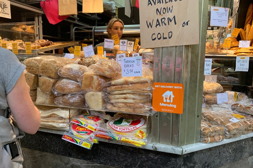 A bakery shop front with stacks of bread on display.