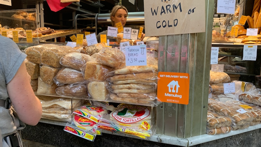 A bakery shop front with stacks of bread on display.