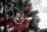Toy handcuffs on a Christmas tree.