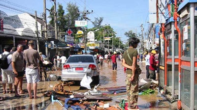 Inundated: residents and tourists in Phuket assess the damage.