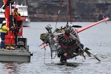 NSW Police and salvage personnel lift the body of the wreckage of a seaplane