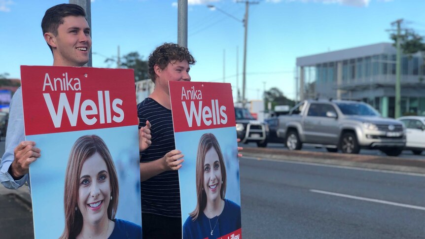 Supporters hold placards of of Anika Wells in the seat of Lilley.