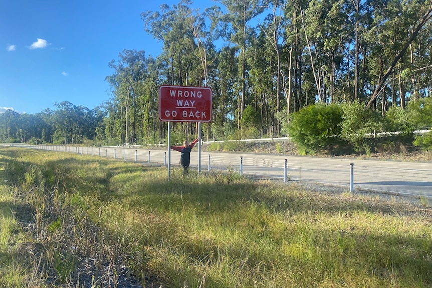  A woman with a sign that says wrong way go back