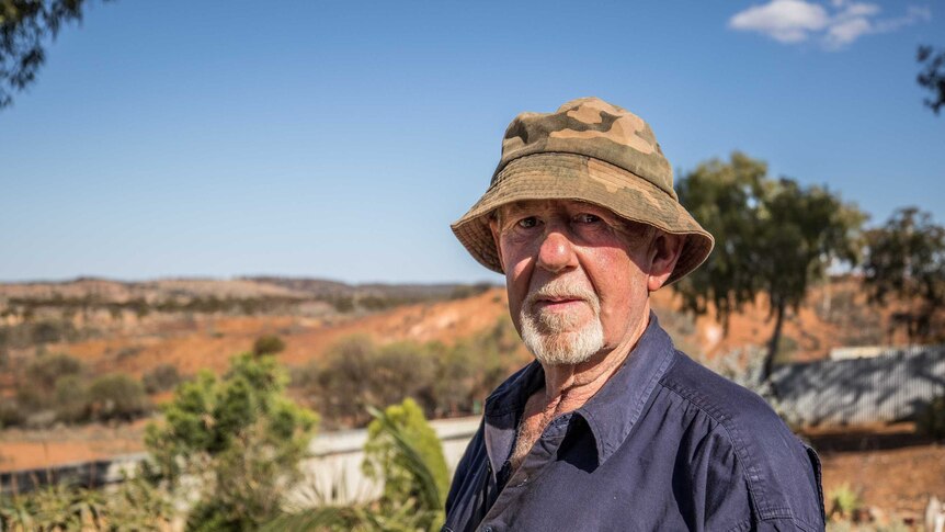 A retiree in his backyard in a rural setting