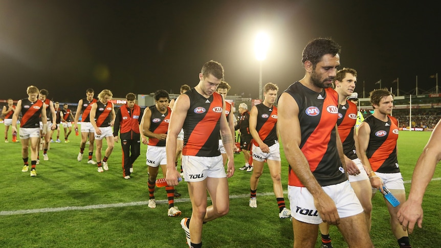 Bombers players troop off the field after a heart-breaking four point loss to Adelaide.