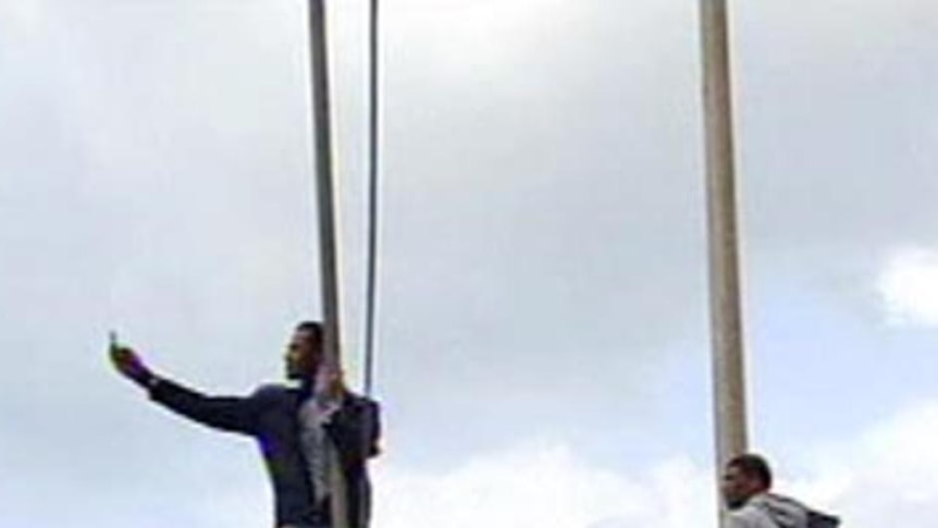 Protesters climb poles during a gathering of anti-government protesters in Benghazi.