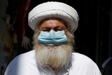 A Jordanian man with a big beard and a medical face mask