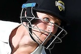 Cameron Bancroft watches a red cricket ball approach his head and holds his bat at a 80 degree angle behind him
