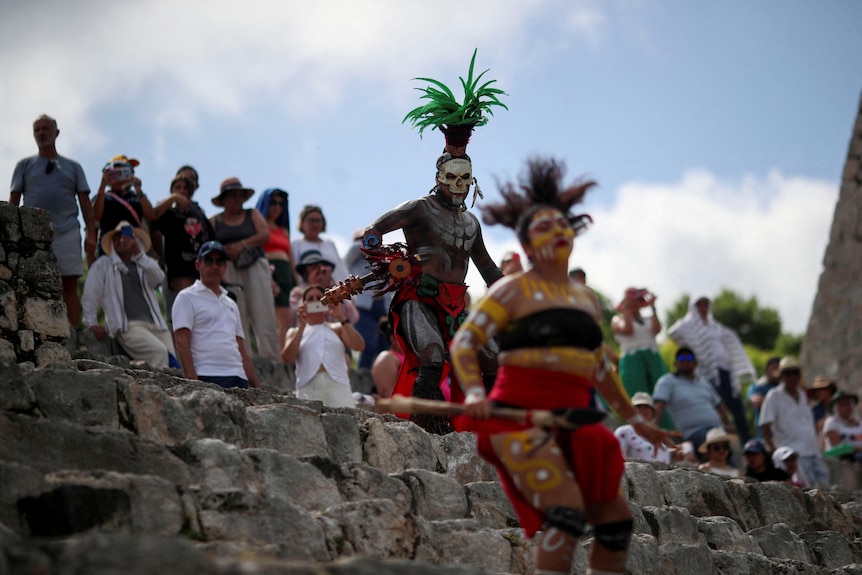 A person dressed as Mayan god of death Ah Puch no the steps of the Edzna archeological site.