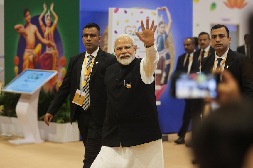 Narendra Modi waves with an arm raised in the air.