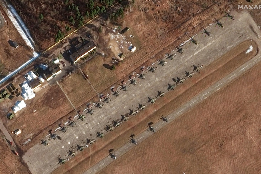 Helicopters and military units are seen from the air.