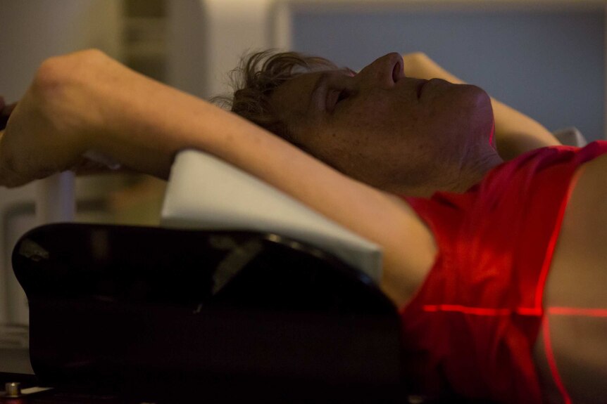 Sue Jensen lies back during radiotherapy treatment.