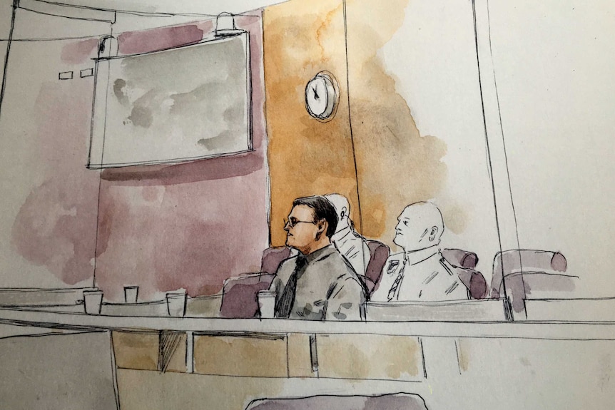 Sketch of a bespectacled man sitting in the dock of a court with two guards behind him.