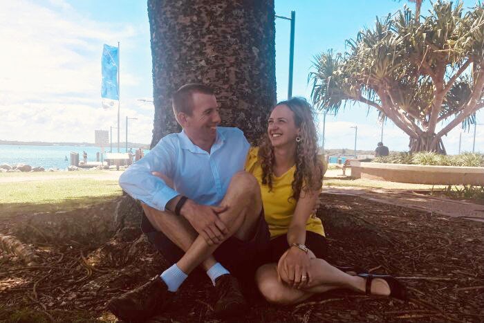 Nicki Jeffery sitting with her husband under a tree in Port Macquarie