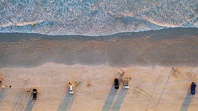 An aerial shot of beach goers lining Cable Beach near Broome, WA