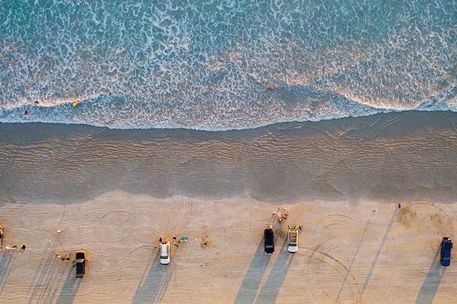 An aerial shot of beach goers lining Cable Beach near Broome, WA