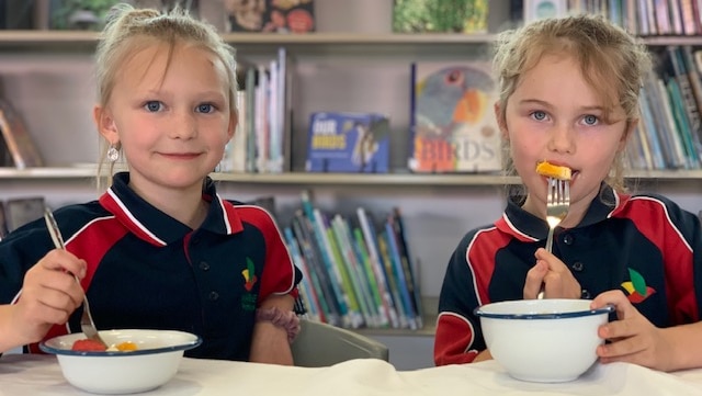 Two girls eating school lunch.