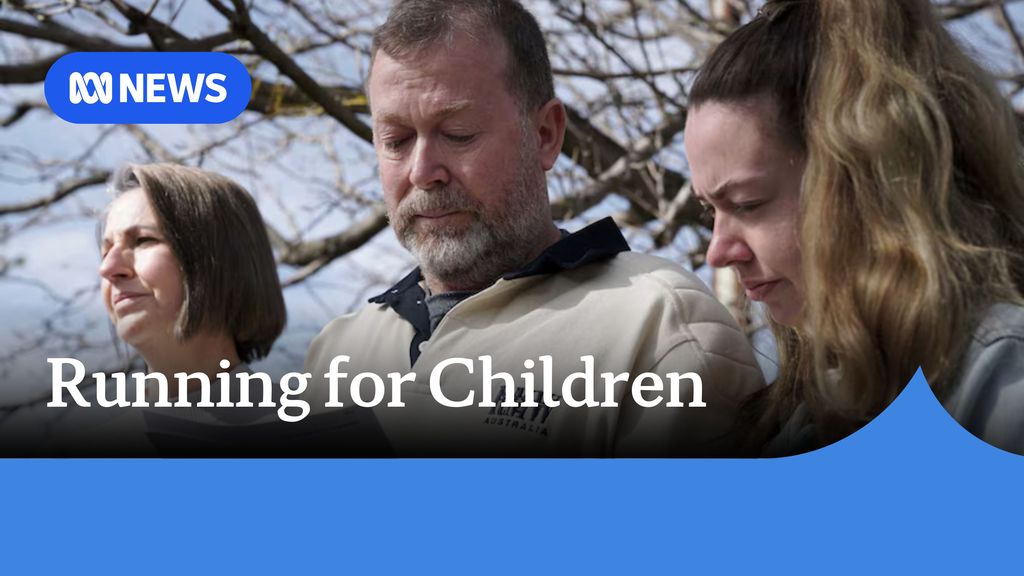 Running for Children: A man and two women with their heads bowed. The branches of a tree are behind them.