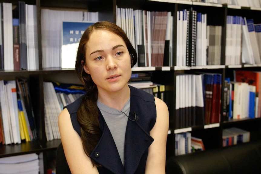 Close-up photo of Yulia Gorbunova in front of a bookshelf.