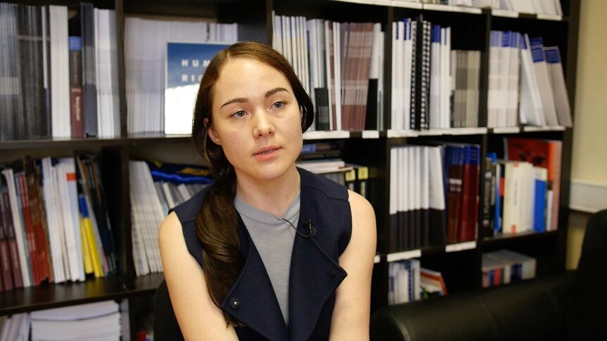 Close-up photo of Yulia Gorbunova in front of a bookshelf.