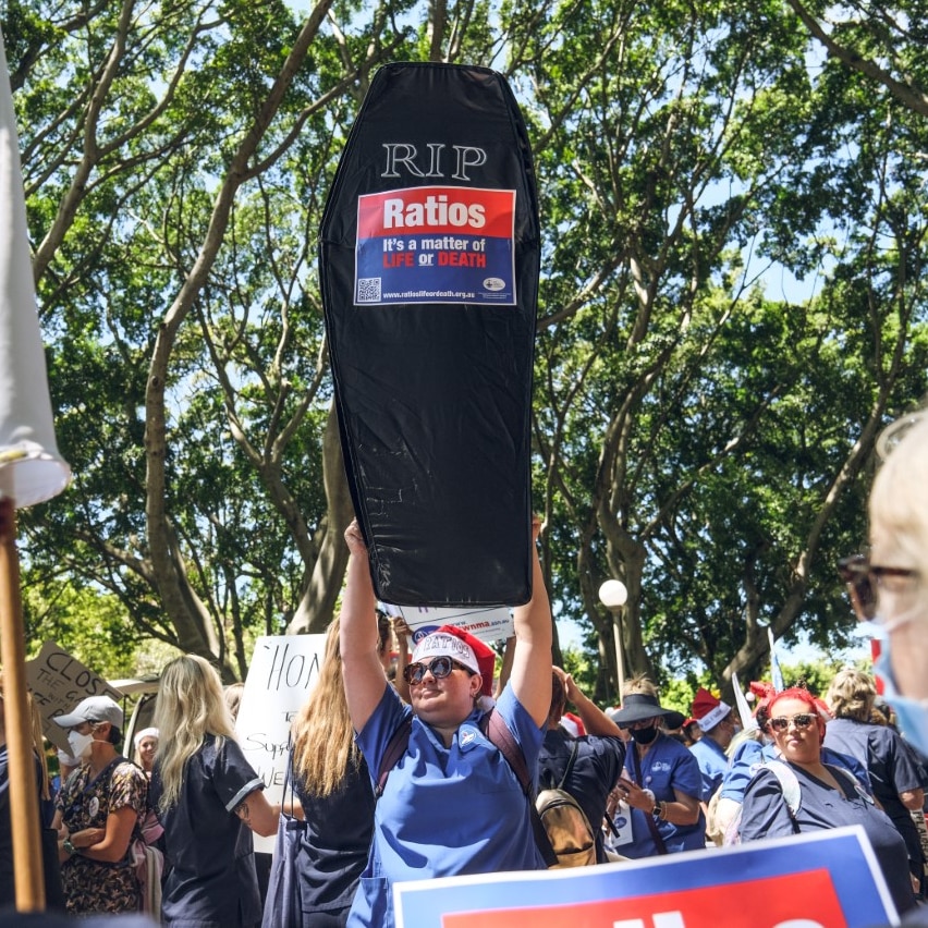 A woman holding a coffin in a protest