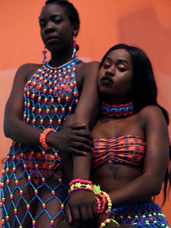 two women wearing colourful body and neck ornaments