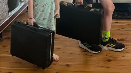 two young people carrying briefcases near their shoes