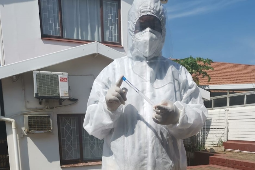 Dr Mvuyisi Mzukwa holds a swab used for COVID testing outside his surgery in KwaZulu Natal