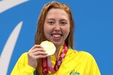 An Australian female swimmer holds her gold medal with her right hand at the Tokyo Paralympics.