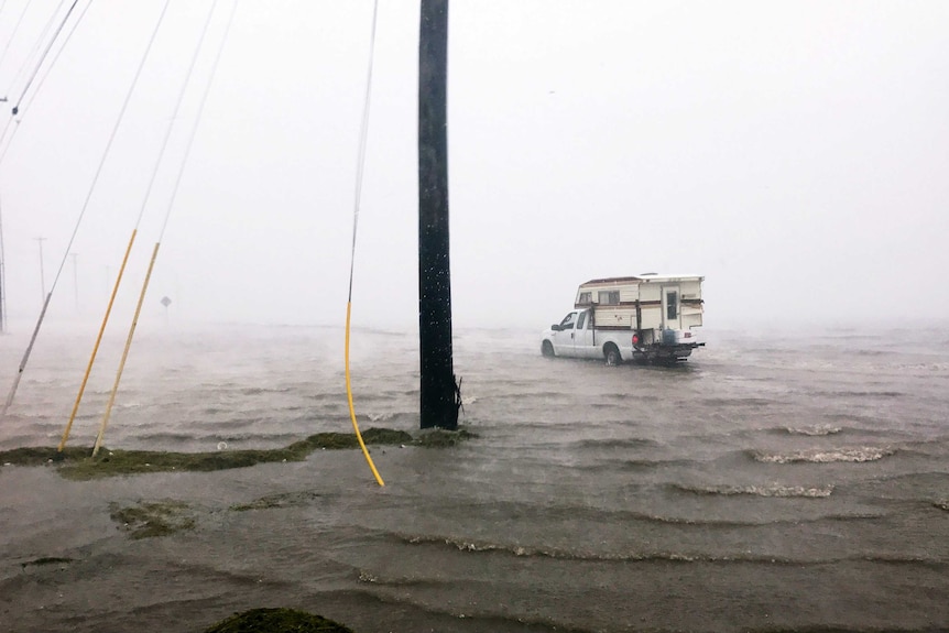 A car is bogged in floodwaters as the storm makes landfall